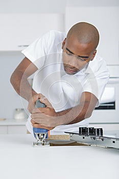 Man making hole for ceramic hob with jigsaw