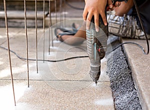 Man making a hole in the concrete floor using a drill