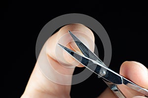 Man is making a manicure scissors. Procedures at home. Cutting nails