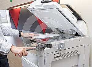 Man making photocopy of document on a copy machine with access control for key card.