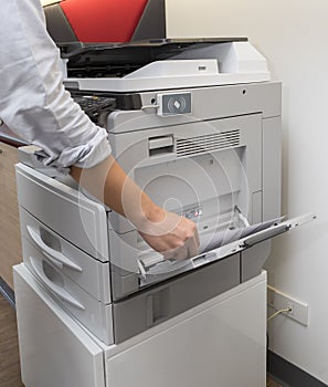 Man making photocopy of document on a photocopier machine with access control for key card.