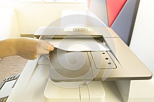 Man making photocopy with sheet of paper on Photocopier with access control panel.