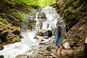 Man making photos of the waterfall in the forest