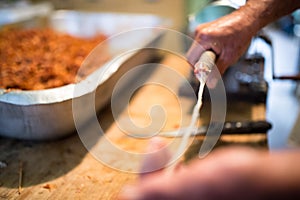 Man making sausages the traditional way using sausage filler.