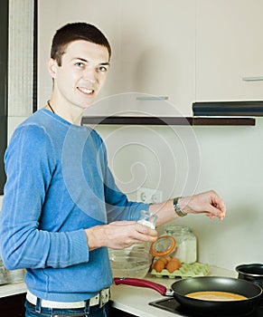 Man making scrambled eggs in frying pan