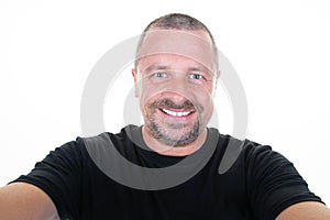 Man making smartphone selfie with cellphone over isolated white background middle aged handsome guy portrait