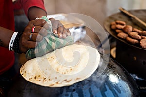 Man making an ulta tawa paratha bread on an upturned pot mughal cuisine from india and pakistan