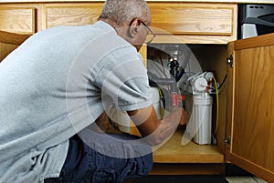 Man making under sink repairs