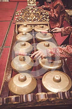 Man with Malay songket costume playing traditional music instrument called Gamelan. selective focus shot