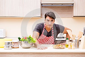 The man male cook preparing food in kitchen