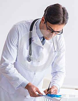 Man male pediatrician near baby bed preparing to examine