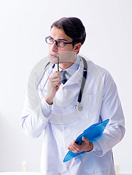 The man male pediatrician near baby bed preparing to examine