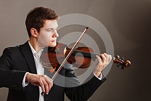 Man man dressed elegantly playing violin