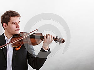 Man man dressed elegantly playing violin