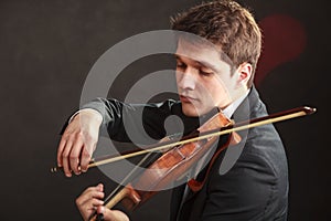 Man man dressed elegantly playing violin