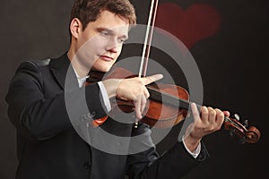 Man man dressed elegantly playing violin