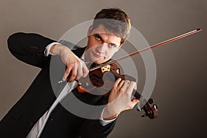 Man man dressed elegantly playing violin