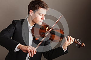 Man man dressed elegantly playing violin