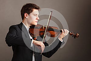 Man man dressed elegantly playing violin