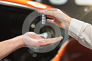 Man manager giving keys from brand new car to his woman client , successful purchase deal, cooperation