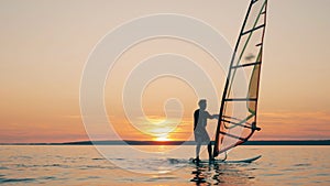 A man is managing a sail of a windsurf board while floating