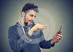 Man manipulating with smarpthone and gesturing