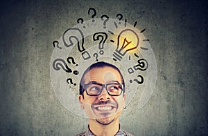 Man with many questions and solution light bulb above head photo