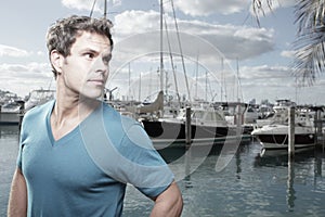 Man at a marina glancing over his shoulder