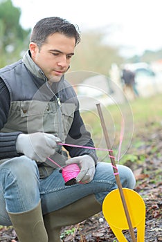 Man marking boundary with string