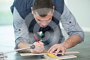 man marking tile to be cut