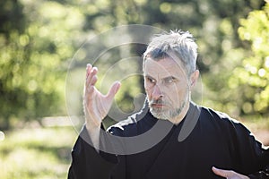 A man martial artist and qigong master practicing tai Chi Taiji Chuan in a Park