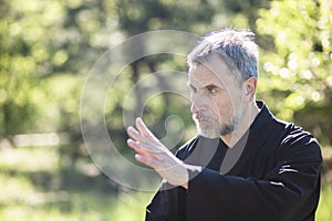 A man martial artist and qigong master practicing tai Chi Taiji Chuan in a Park