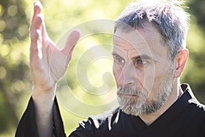 A man martial artist and qigong master practicing tai Chi Taiji Chuan in a Park