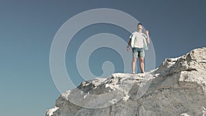 A man with a masculine perfume in his hands on an elevated white mountain.