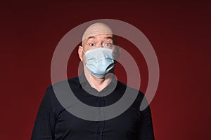 Man with mask and gloves with face surprise expresion on red background photo