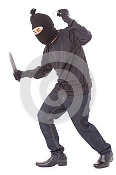Man in a mask holding flashlight with a knife