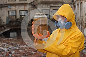 Man with mask and protective clothes explores danger jar. r