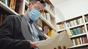 Man in mask reading book in book shop