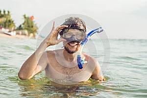 A man with a mask and snorkel is going to dive into the sea