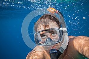 Man with mask snorkeling in clear water