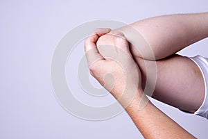 A man massages his elbow to suppress pain