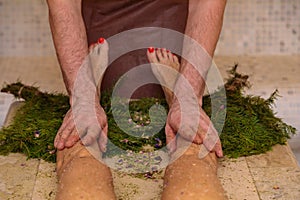 A man massaging a woman& x27;s legs in a hammam