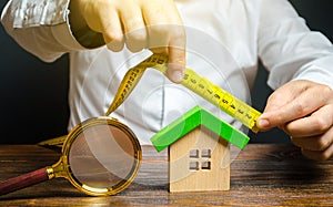 A man measures and evaluates a house. Fair value of real estate and housing. Property valuation. Home appraisal. Legal deal