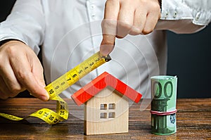 A man measures and evaluates a house. Fair value of real estate and housing. Property valuation. Home appraisal. Legal deal