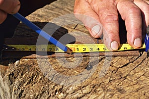 A man measures an iron for cutting