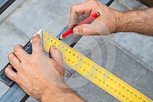 Man measures metal with a ruler for cutting