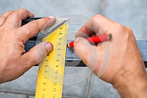 Man measures metal with a ruler for cutting