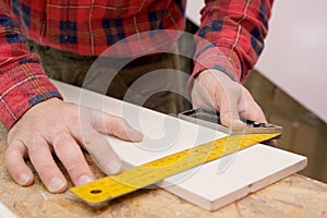 Man Measuring A Board