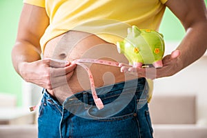 The man measuring body fat with tape measure in dieting concept