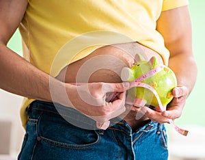 Man measuring body fat with tape measure in dieting concept